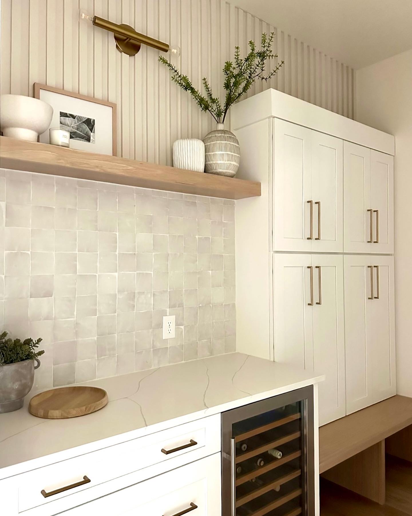 A mudroom used as a multifunctional space with lockers and beverage center! #mudroom #beveragecenter #bar #lockers #interiordesign #whitecabinets #whitecabinetry #whitemudroom